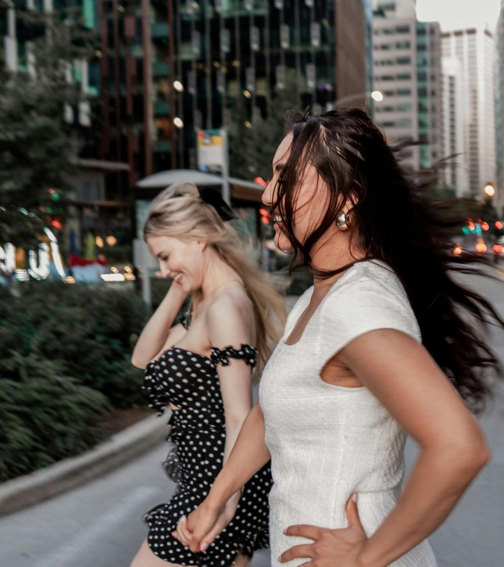 Two friends laughing on a city street