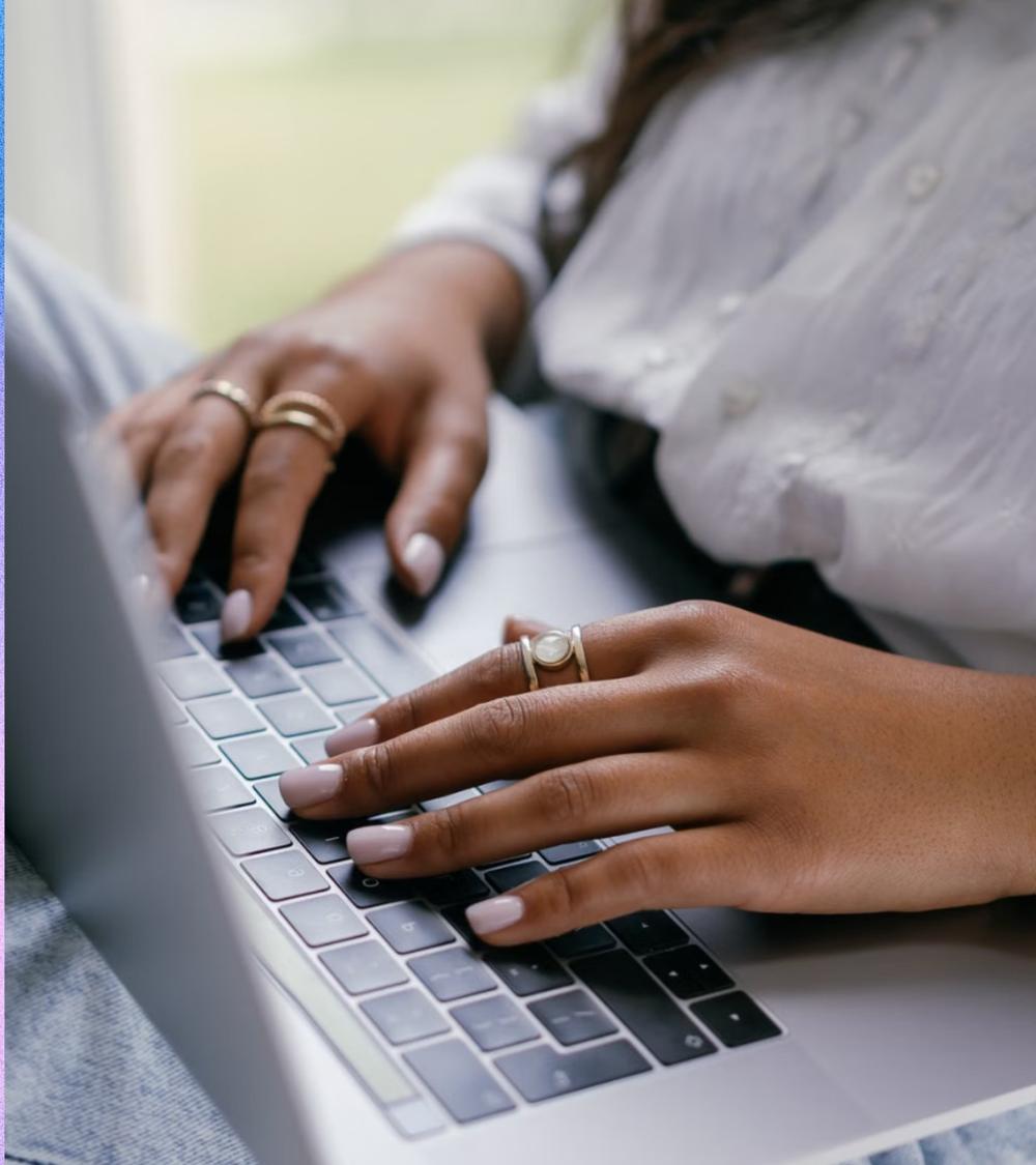 Hands typing on a laptop
